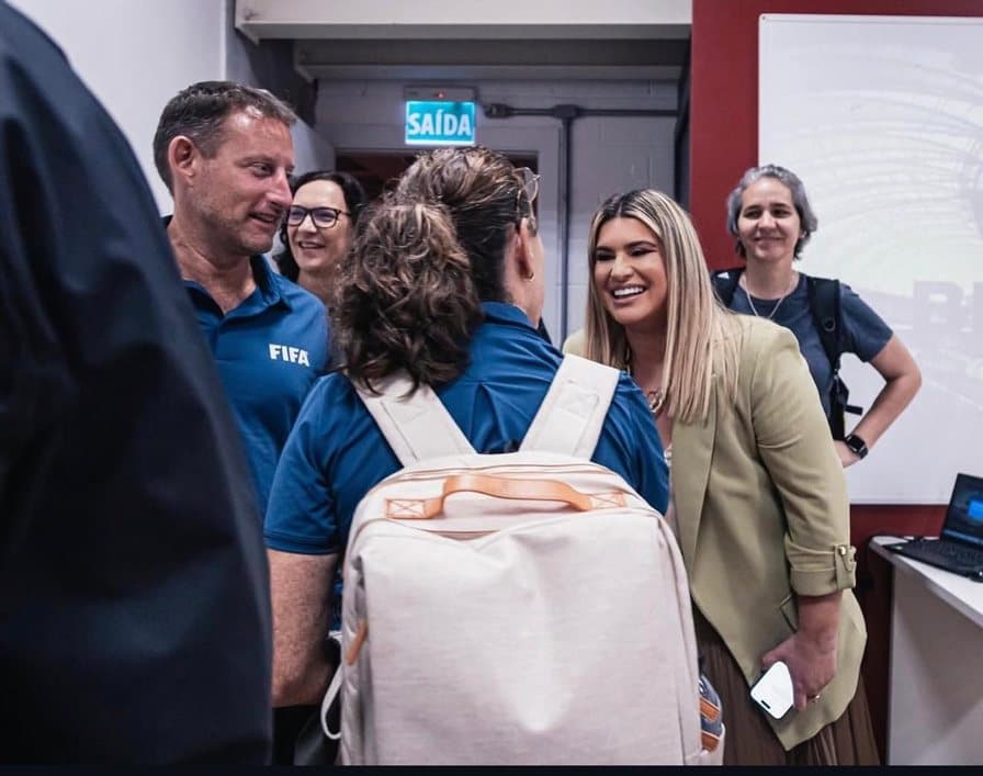 Carla Larini conversando com representantes da FIFA